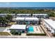An aerial view highlighting a condominium complex with a swimming pool and a serene backdrop of trees at 22375 Edgewater Dr # 123, Punta Gorda, FL 33980