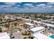 Aerial shot of condo buildings with parking and landscaping, with tennis courts and pool in background under a cloudy, blue sky at 22375 Edgewater Dr # 123, Punta Gorda, FL 33980