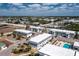 An aerial view of condo buildings with landscaping, parking, tennis courts and pool under a bright blue sky with clouds at 22375 Edgewater Dr # 123, Punta Gorda, FL 33980