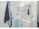 Clean bathroom with white cabinets, a sink, and a mirror, complemented by blue accents at 22375 Edgewater Dr # 123, Punta Gorda, FL 33980