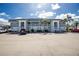 Condominium building featuring a well-maintained exterior, ample parking, and lush landscaping with palm trees under a bright sky at 22375 Edgewater Dr # 123, Punta Gorda, FL 33980