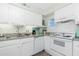 Bright kitchen featuring white cabinetry, granite counters, and modern appliances for easy cooking at 22375 Edgewater Dr # 123, Punta Gorda, FL 33980