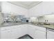 Open kitchen with granite counters and white cabinets seamlessly flows into the adjacent dining and living area at 22375 Edgewater Dr # 123, Punta Gorda, FL 33980
