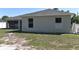Home exterior featuring a screened patio, backyard with lawn, and windows allowing natural light into the home at 2250 Homestead Cir, North Port, FL 34286