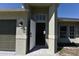 Entrance of the home featuring a gray front door and elegant exterior lighting fixtures at 2250 Homestead Cir, North Port, FL 34286