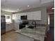 Bright kitchen featuring stainless steel appliances, granite countertops, and white cabinets at 2250 Homestead Cir, North Port, FL 34286