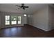 Bright living room with dark wood floors, ceiling fan, and a view of the front yard at 2250 Homestead Cir, North Port, FL 34286