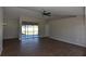Spacious living room with dark floors, ceiling fan, and sliding doors to the lanai at 2250 Homestead Cir, North Port, FL 34286