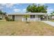 Charming single-story home with white picket fence and mature trees, featuring a covered carport at 2331 Cannolot Blvd, Port Charlotte, FL 33948