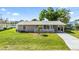 Charming single-story home with a well-maintained lawn, mature trees, and a welcoming front entrance at 2331 Cannolot Blvd, Port Charlotte, FL 33948