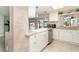 Well-lit kitchen featuring white cabinets, stainless steel appliances, and a view of the backyard at 2331 Cannolot Blvd, Port Charlotte, FL 33948