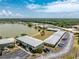 A detailed aerial view of lakeside apartments with well-maintained grounds, landscaping, and ample parking at 25225 Rampart Blvd # 1603, Punta Gorda, FL 33983
