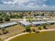 Aerial view of lakeside apartments with well-maintained landscaping and lake access at 25225 Rampart Blvd # 1603, Punta Gorda, FL 33983