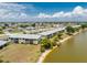 Aerial view showcases lakeside apartments with well-maintained grounds, landscaping, and lake access at 25225 Rampart Blvd # 1603, Punta Gorda, FL 33983