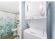 Well-organized bathroom featuring stacked washer/dryer, toilet, and shower with stylish curtain at 25225 Rampart Blvd # 1603, Punta Gorda, FL 33983