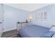 Bright bedroom featuring light blue walls, modern flooring, and a window with white shutters at 25225 Rampart Blvd # 1603, Punta Gorda, FL 33983