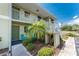 Charming condo exterior with lush landscaping, a small palm tree, and a cozy seating area at 25225 Rampart Blvd # 1603, Punta Gorda, FL 33983