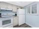 Bright kitchen featuring white cabinets, granite countertops, updated appliances, and a window at 25225 Rampart Blvd # 1603, Punta Gorda, FL 33983