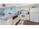 Bright kitchen featuring white cabinets, granite countertops, updated appliances, and an adjacent dining area at 25225 Rampart Blvd # 1603, Punta Gorda, FL 33983