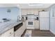 Bright kitchen featuring white cabinets, granite countertops, updated appliances, and an adjacent dining area at 25225 Rampart Blvd # 1603, Punta Gorda, FL 33983