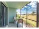 Serene screened lanai with a cozy seating area offers tranquil views of the lush green lawn and shimmering lake at 25225 Rampart Blvd # 1603, Punta Gorda, FL 33983