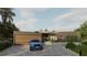 Contemporary home featuring a wooden garage door, landscaped walkway, and a blue car parked on the paved driveway at 2523 Ryan Blvd, Punta Gorda, FL 33950