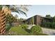 Beautiful exterior view showcasing modern architecture, a well-manicured lawn, mature trees, and a blue car parked nearby at 2523 Ryan Blvd, Punta Gorda, FL 33950