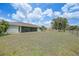 Expansive fenced backyard featuring a well-maintained lawn, mature trees, and screened-in lanai at 26103 Salonika Ln, Punta Gorda, FL 33983