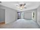 Bright bedroom featuring plush carpet, ceiling fan, and sliding glass doors with views of the outdoor space at 26103 Salonika Ln, Punta Gorda, FL 33983
