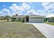 Charming single-story home with a well-maintained lawn and attached two-car garage at 26103 Salonika Ln, Punta Gorda, FL 33983
