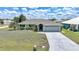Beautifully landscaped home with a paved driveway, a two-car garage, and lush green lawn at 26103 Salonika Ln, Punta Gorda, FL 33983