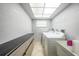 Well-lit laundry room with white appliances, tile floor, storage cabinets, and a utility sink at 26103 Salonika Ln, Punta Gorda, FL 33983