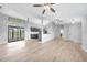 Spacious living room with modern flooring, a stylish lighting fixture and seamless access to the kitchen at 26103 Salonika Ln, Punta Gorda, FL 33983