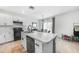 Open kitchen showcasing white cabinets, stainless steel appliances, island seating, and a view of the dining area at 27306 Deep Creek Blvd, Punta Gorda, FL 33983