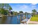Scenic canal view featuring a private boat dock and lush landscaping, great for boating enthusiasts at 2911 Riverside Dr, Punta Gorda, FL 33950