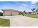 Charming single-story home featuring a spacious three-car garage, lush lawn, and wide driveway at 2911 Riverside Dr, Punta Gorda, FL 33950