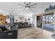 Open-concept living room featuring hardwood floors, access to the screened patio and pool, and a large ceiling fan at 2911 Riverside Dr, Punta Gorda, FL 33950