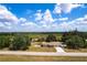 Expansive aerial view of a home with a large yard, mature trees, and a sparkling swimming pool at 30154 Beech Rd, Punta Gorda, FL 33982