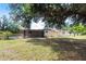 A view of the backyard with a screened porch, grassy area, and fencing at 30154 Beech Rd, Punta Gorda, FL 33982