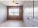 Bedroom featuring wood-paneled walls, tile flooring, and a window providing natural light, creating a cozy retreat at 30154 Beech Rd, Punta Gorda, FL 33982