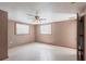 Spacious bedroom featuring neutral walls, tile flooring, a ceiling fan, and windows providing ample natural light at 30154 Beech Rd, Punta Gorda, FL 33982