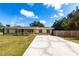 Charming ranch home with a front porch, green trim, long cracked driveway, and a well-maintained lawn at 30154 Beech Rd, Punta Gorda, FL 33982