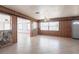 Spacious living room with tile flooring, stone accents, wood paneling, ceiling fan, and natural light at 30154 Beech Rd, Punta Gorda, FL 33982