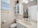 Bright bathroom with a vanity sink, toilet, mirrored medicine cabinet, and enclosed shower at 3050 Rivershore Ln, Port Charlotte, FL 33953