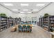 An inviting library features extensive bookshelves, comfortable seating, and a spacious table for collaborative work at 3050 Rivershore Ln, Port Charlotte, FL 33953