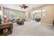 Bright living room with neutral carpet, large windows, and an open layout flowing into the dining area at 3050 Rivershore Ln, Port Charlotte, FL 33953