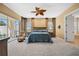 Spacious main bedroom featuring a ceiling fan, neutral carpet, and a sliding glass door to the lanai at 3050 Rivershore Ln, Port Charlotte, FL 33953