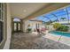 Charming pool area with a screened enclosure, bar seating, and manicured landscaping at 3050 Rivershore Ln, Port Charlotte, FL 33953