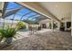 Inviting pool area with a screened enclosure, patio seating, and lush landscaping at 3050 Rivershore Ln, Port Charlotte, FL 33953