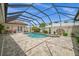 Screened-in pool area with a heated pool, spa, lush landscaping, and outdoor seating at 3050 Rivershore Ln, Port Charlotte, FL 33953